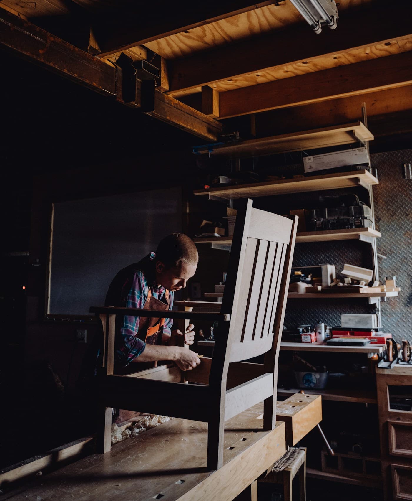 Craftsman assembling a solid wood chair frame in the workshop